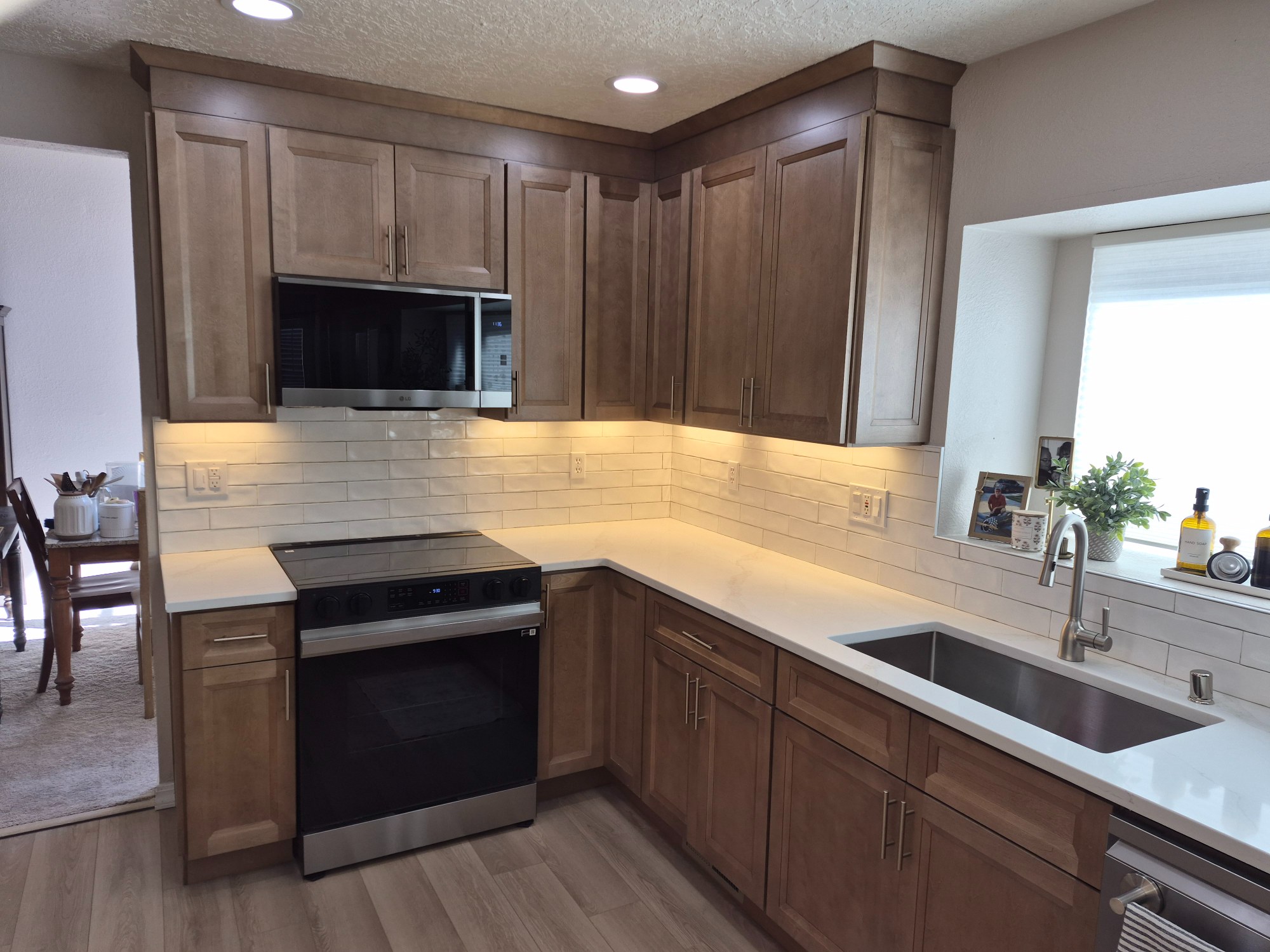 Full Measure kitchen project KIT26-008 with wood cabinets, white countertops and a stainless range